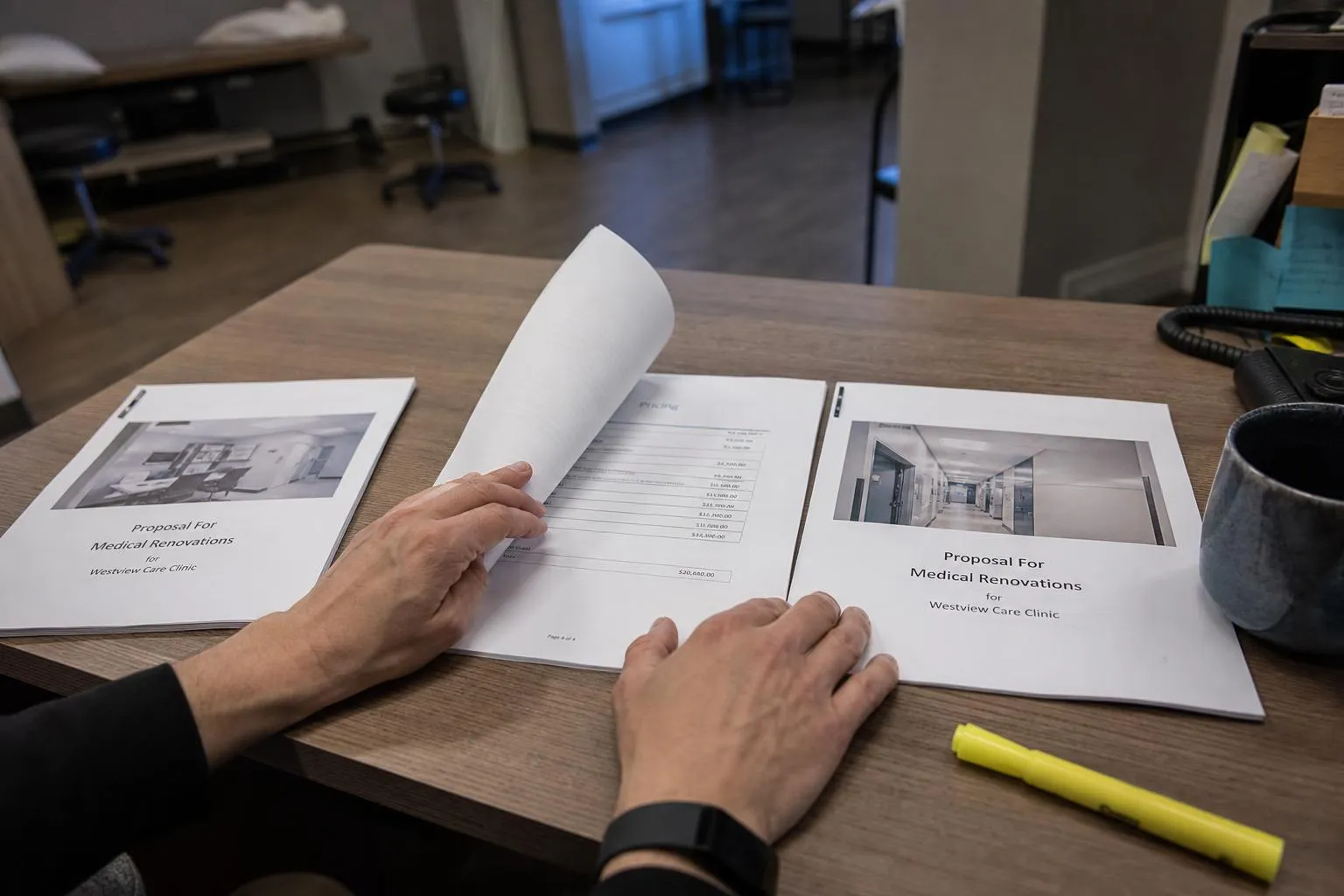 A practice administrator comparing three vendor proposals spread across a desk